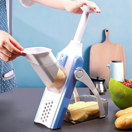 Person using a kitchen slicer to cut vegetables on a table with a blue background.