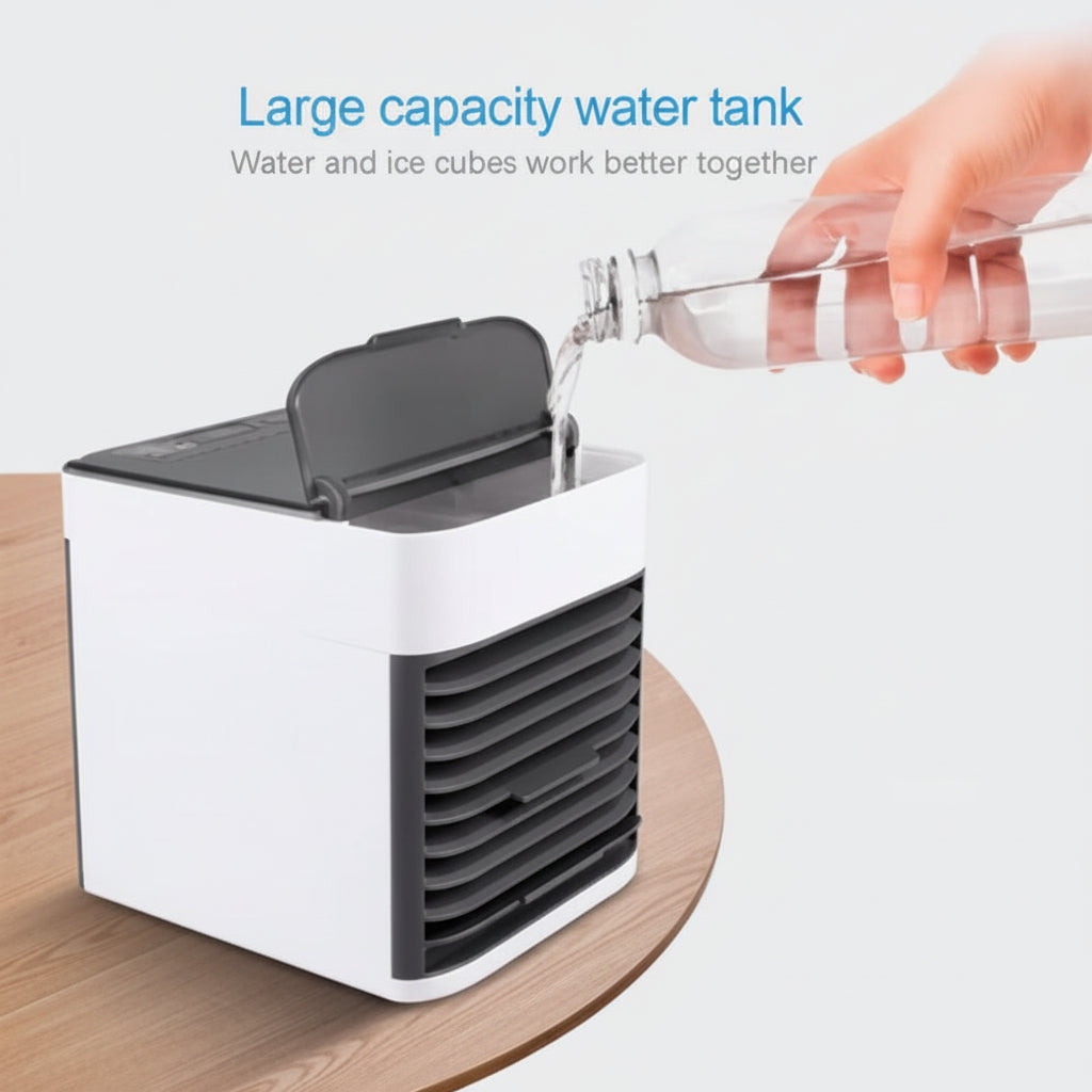 Small air cooler with a large capacity water tank on a wooden surface, showing a hand pouring water from a bottle.
