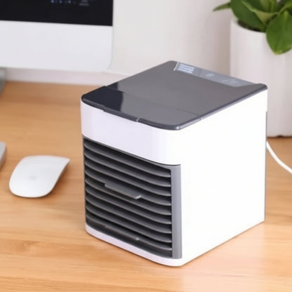 Small portable air conditioner on a desk with a computer mouse and plant in the background